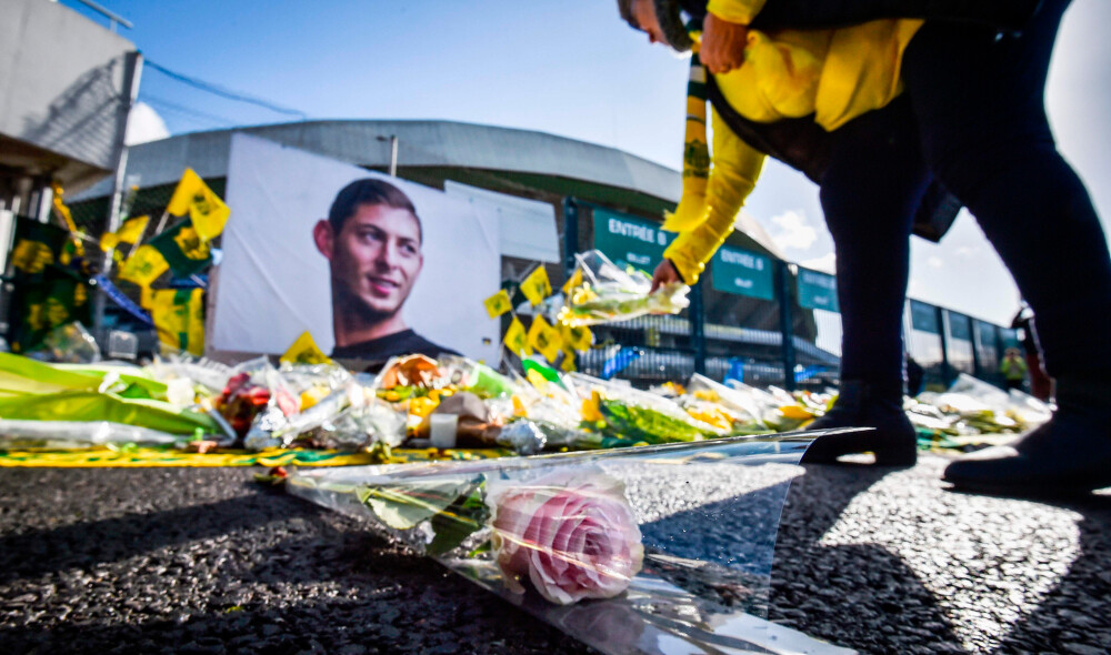 zzzzinte1A FC Nantes supporter puts yellow flowers in front of the portrait of late Argentinian forward Emiliano Sala prior to the French L1 football match between FC Nantes and Nimes Olympique at the La Beaujoire stadium in Nantes, western France on February 10, 2019. - FC Nantes football club announced on February 8, 2019 that it will freeze the #9 jersey as a tribute to Cardiff City and former Nantes footballer Emiliano Sala who died in a plane crash in the English Channel on January 21, 2019. (Photo by LOIC VENANCE / AFP)zzzz