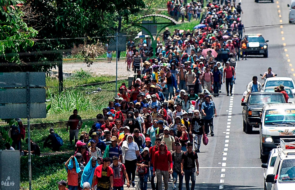 zzzzinte1Central American migrants heading to the US walk in caravan along the route between Metapa and Tapachula in Mexico on April 12, 2019. - A group of 350 Central American migrants forced their way into Mexico Friday, authorities said, as a new caravan of around 2,500 people arrived -- news sure to draw the attention of US President Donald Trump. Mexico's National Migration Institute said some members of the caravan had a "hostile attitude" and had attacked local police in the southern town of Metapa de Dominguez after crossing the border from Guatemala. (Photo by Pep COMPANYS / AFP)zzzz