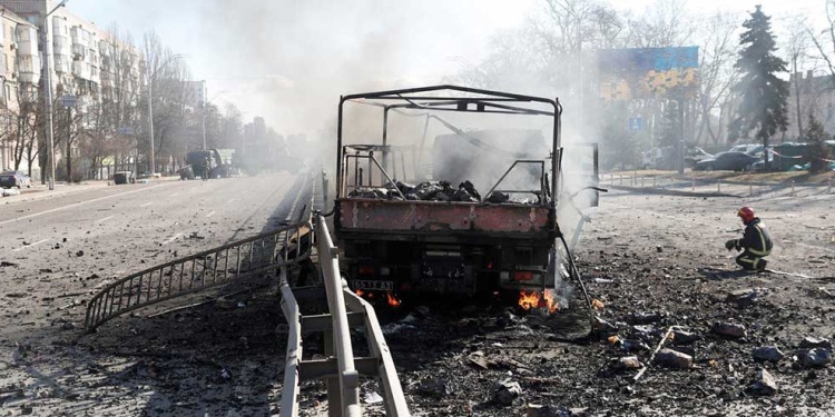 Un bombero ucraniano se arrodilla junto a un vehículo destruido tras la ofensiva rusa contra Ucrania, en Kiev. Foto: REUTERS
