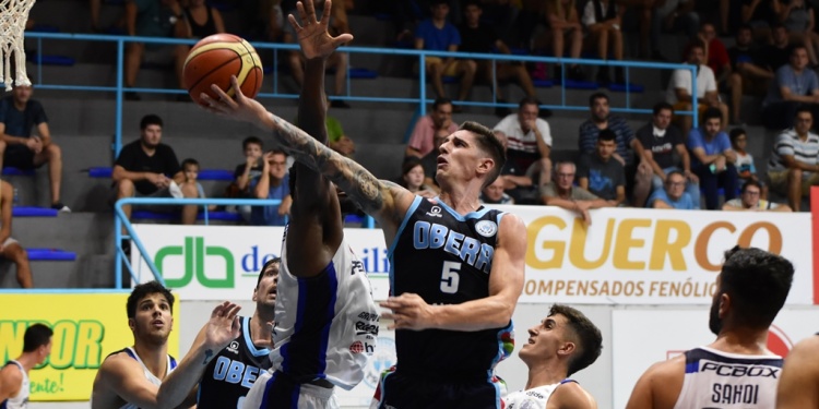 EL GUÍA. Nicolás De los Santos (5) ensaya la bandeja ante la presión de un rival. Se destacó ante el Milrayitas.