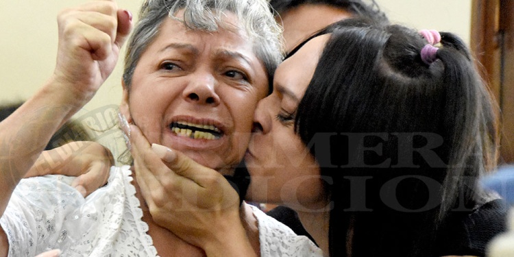 BESO, ABRAZO Y JUSTICIA PARA EVELYN. Yeilin se aferra a su madre que sostiene la imagen de la víctima en su pecho.
