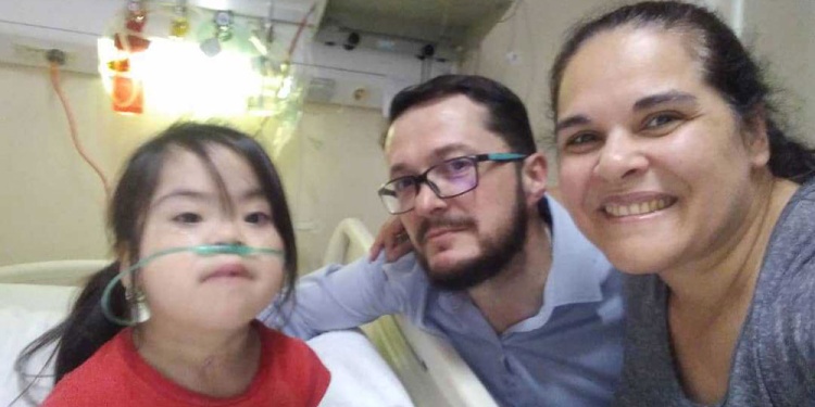 DIEGO GÓMEZ CON SU HIJA. Es la más chica de tres hermanos, tuvo siete cirugías y necesita dos más.