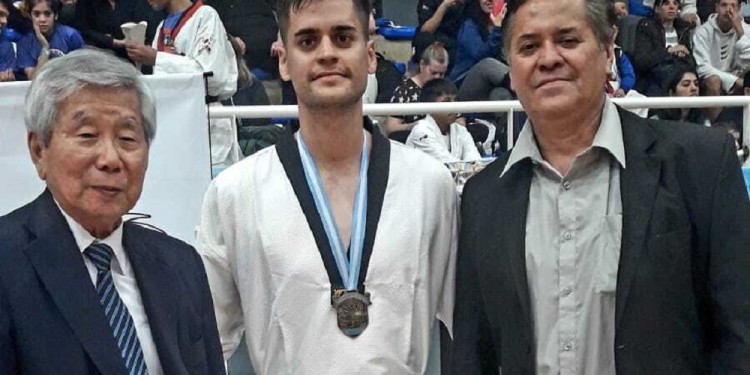 CAMPEÓN. Lucas González, con la de oro y junto al maestro Han Chang Kim, leyenda viva del taekwondo en la Argentina; y Juan, su padre, dirigente local.