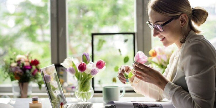 Woman smelling a flower in the office