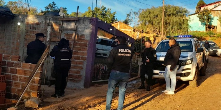 PROCEDIMIENTO. Uniformados de la Dirección Homicidios y de la UR-XII en la casa de uno de los sospechosos, donde hallaron la motocicleta roja.