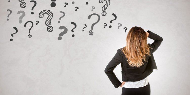 65211369 - backside of a businesswoman with question marks around her, isolated in grey