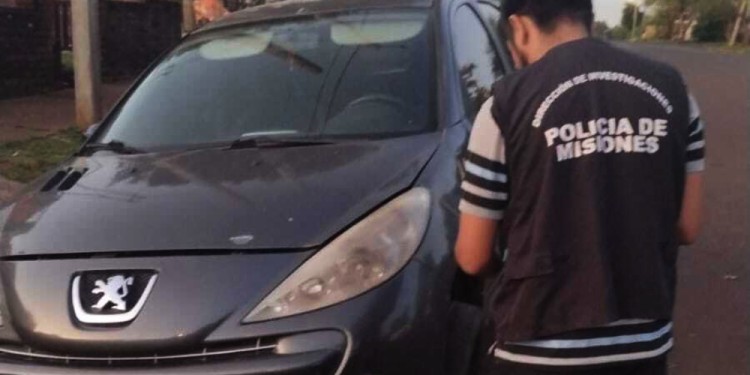 FRENTE A UN TALLER. Un Fiat Mobi y un Peugeot 207.