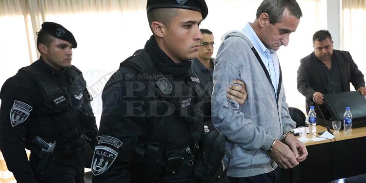 AL PENAL. Personal del Servicio Penitenciario lleva esposado al condenado luego de haber escuchado la sentencia de parte de los jueces (Fotos gentileza C.Olivera Schuster)