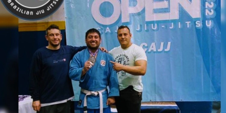 MEDALLA EN MANO. Uno de los atletas junto a los profes de Brasa.