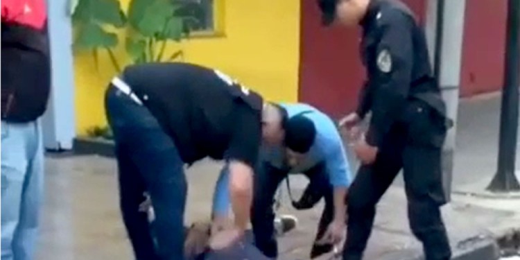 GRABADOS. Los tres policías que redujeron al joven fueron captados por los celulares de jóvenes que salían de bailar. (Captura de video)