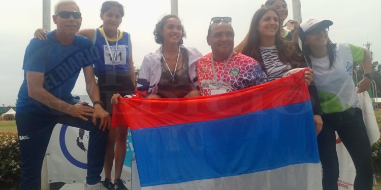 Podio. Cabrera festeja con la bandera de Misiones y su entrenador. Fue la primera medalla para la tierra colorada.