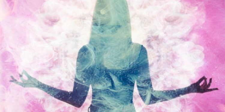 Spiritual practice. Harmony balance. Meditating woman silhouette in pink ethereal smoke double exposition.