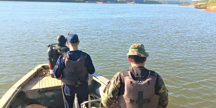 SILENCIO Y TRABAJO INTENSO. Los buzos de la Prefectura comenzaron ayer por la mañana su labor frente a la orilla eldoradense, más embarcaciones se sumaron al procedimiento en conjunto con la Policía provincial.