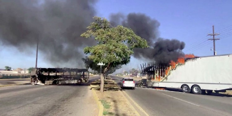 BLOQUEOS. El cártel se apropió de autos y colectivos de ciudadanos para prenderlos fuego y obstruir los accesos. (Foto: Reuters)