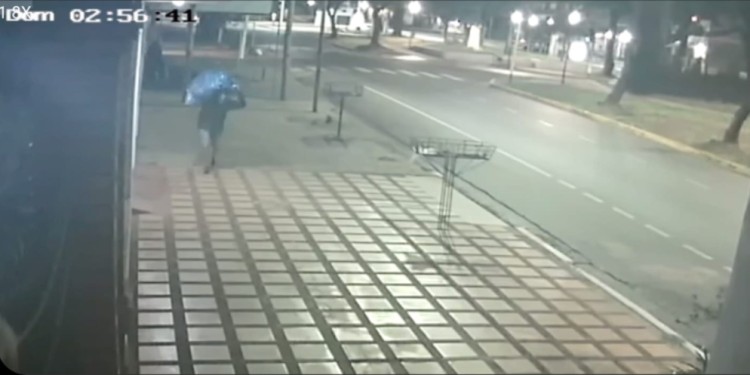 MOMENTO DEL ROBO. Uno de los ladrones cargando un bulto.