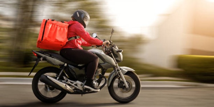 Delivery biker arriving at destination - motogirl