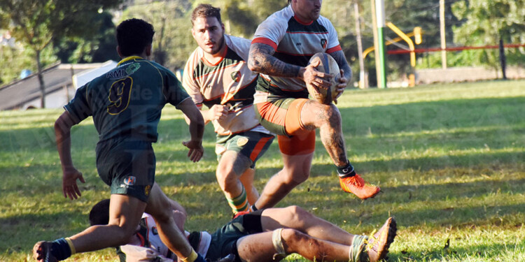 CON DECISIÓN. Iván Zanek encara con pelota dominada rumbo al ingoal de Carayá, mientras Cueva sale al cruce.