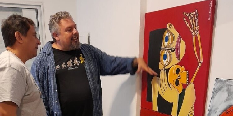 ARTE MISIONERO. El artista Hugo Quintanilla mostrando una de sus pinturas al diputado provincial Martín Cesino.