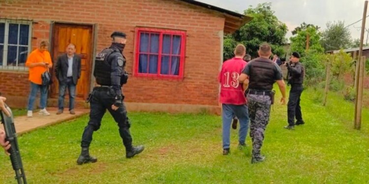 EZEQUIEL BENVENUTO. El acusado (camiseta con el 13 en la espalda) es custodiado durante la audiencia que se realizó en la vivienda de una de las testigo clave, su exsuegra que padece discapacidad motriz.