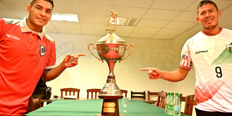 LA COPA EN JUEGO. Nicolás Vallejos de Guaraní y Mauro Gómez, de Brown, junto al trofeo del Torneo Clausura.