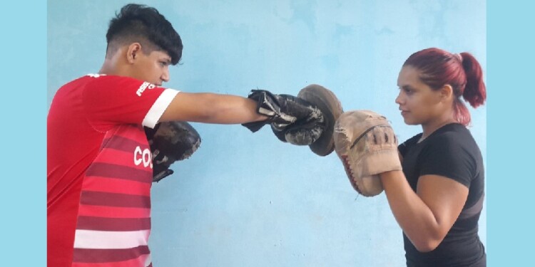EN CLASE. “La Taty”, con su alumno, en su casa donde dicta las clases.