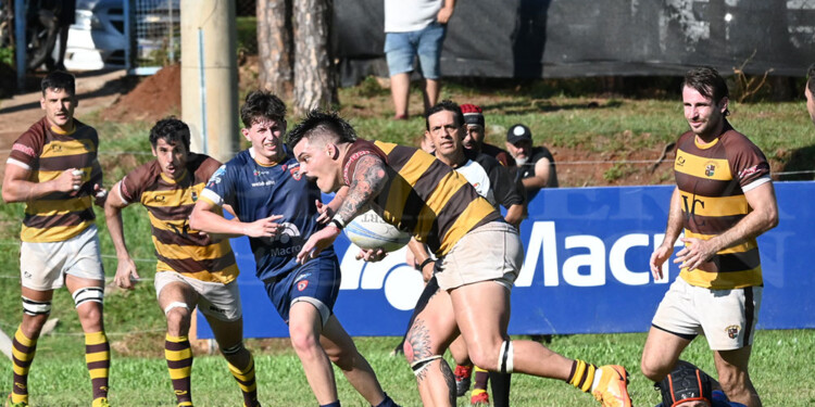 CON DECISIÓN. Fausto Bianchi dejó atrás el tackle de Lucas Tannuri (en el piso) para iniciar un ataque de Tacurú.
