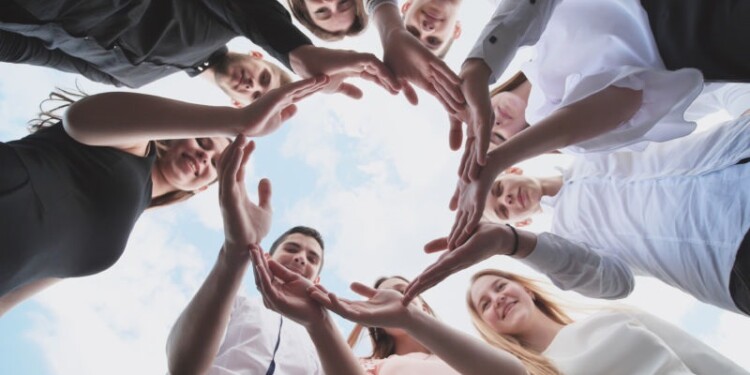 A group of high school students look through the shape of a circle created from their palms. The concept of friendly friends