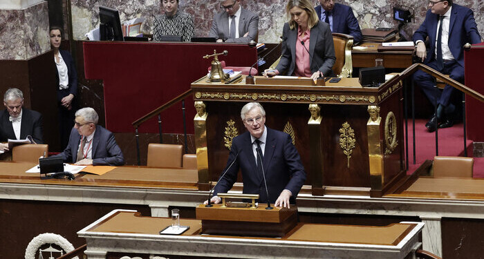 French Prime Minister Michel Barnier (C, down) delivers a speech next to President of the French National Assembly Yael Braun-Pivet (3rdR) during the voting session on the draft of the Social Security bill 2025 at the National Assembly, the French Parliament's lower house, in Paris on December 2, 2024. French Prime Minister faces the biggest risk yet of being deposed by a hostile National Assembly as his government on December 2, 2024, presents a social security financing plan that has the opposition up in arms. These include planned cuts in employer social contributions, a partial end to inflation-indexing of pensions and a less generous prescription drug reimbursement policy. (Photo by STEPHANE DE SAKUTIN / AFP)