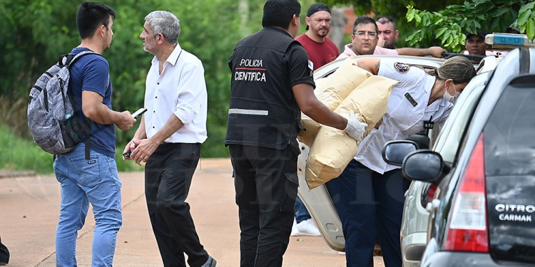 BARRIO NOSIGLIA. Investigadores de la Dirección Homicidios e integrantes de la Dirección Policía Científica durante el procedimiento de ayer a la siesta en la zona sur posadeña.