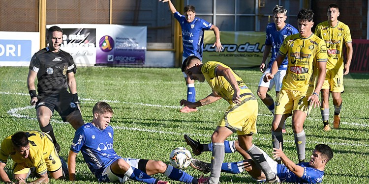 LUCHA. Lucas Marciante intenta quedarse con la pelota, mientras dos rivales de La Crema buscan frenarlo desde el piso.