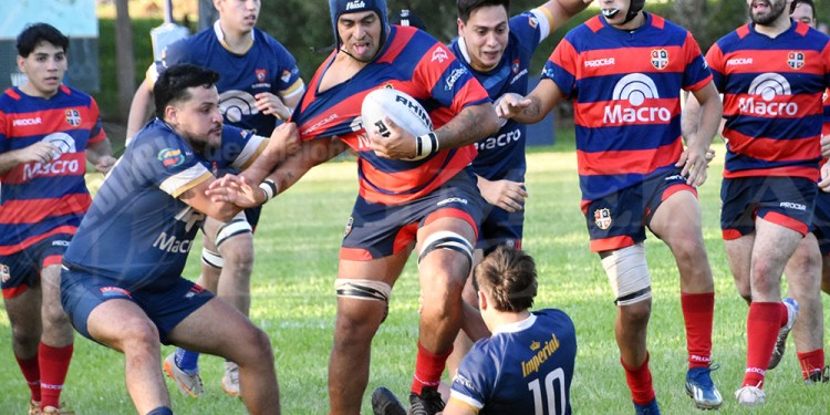 SIN TREGUA. Matías Mauri intenta avanzar, ante el “camiseteo” de un rival. El clásico tuvo de todo en Villa Cabello.