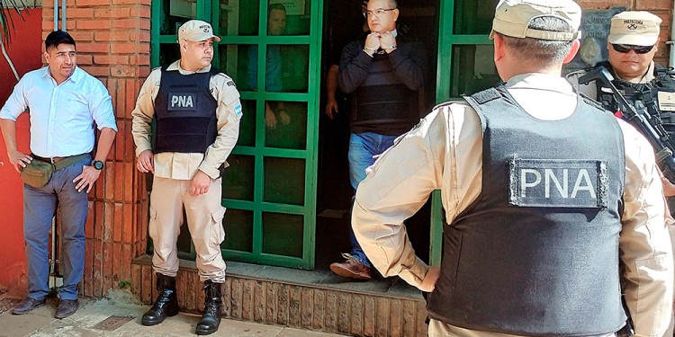 FIN DE JORNADA. El comandante de Gendarmería, Marcos Duette, se retira del TOF-Posadas esposado y escoltado por la PSA y la Prefectura Naval Argentina.