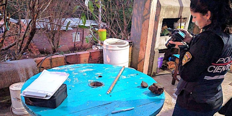 PERICIAS. Una agente analiza y registra las evidencias en la escena del fallido asalto, entre ellas el palo de escoba.