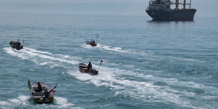 Basij paramilitary force speed boats are sailing along the Persian Gulf near a general cargo vessel during the IRGC marine parade, which is commemorating the Persian Gulf National Day, near the Bushehr nuclear power plant in the seaport city of Bushehr, Bushehr province, in the south of Iran, on April 29, 2024. The Persian Gulf National Day is celebrated on the 10th of Ordibehesht in the Iranian calendar, corresponding to late April or early May. The day marks the anniversary of the expulsion of the Portuguese from the Strait of Hormuz and the Persian Gulf in 1622 by the Safavid forces led by Imam Quli Khan under the command of Shah Abbas I. (Photo by Morteza Nikoubazl/NurPhoto via Getty Images)