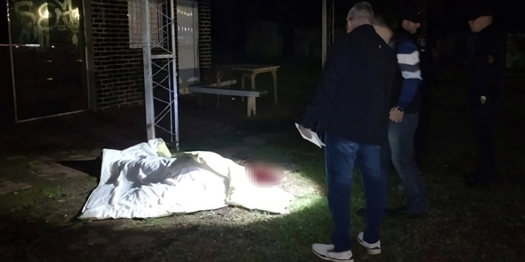 VÍCTIMA. Investigadores de la Unidad Regional VIII junto al cuerpo de Ayala frente a su bar, donde fue masacrado a patadas.